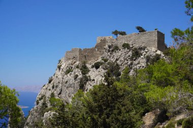 Akdeniz'e bakan 100 metre yüksekliğindeki dik kaya yüzünün üzerine tünemiş Monolithos kalesinin dramatik manzarası.                               