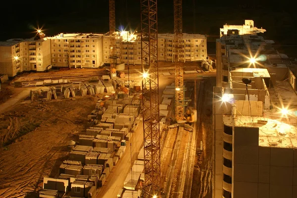 Night works in construction site of a multi storey apartment house with cranes
