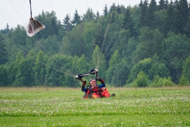 Vatulino, 03 Temmuz 2018: Paraşütle atlayanların inişi. Mutlu ve gülümsüyorlar.       