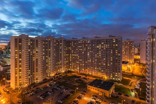 Bir konut çok katlı apartmanın üst görünümü. Pitoresk gün batımı. Gece şehrinin ışıkları