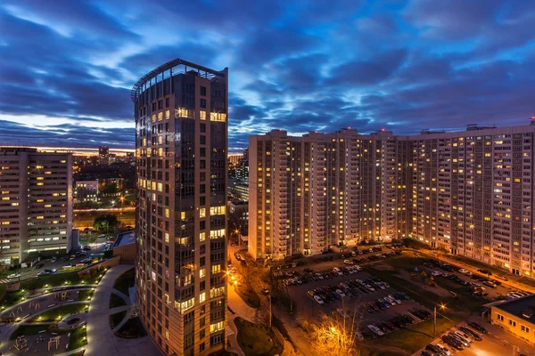 Bir konut çok katlı apartmanın üst görünümü. Pitoresk gün batımı. Gece şehrinin ışıkları