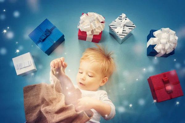 Bebé sonriente en manta roja con regalos —  Fotos de Stock