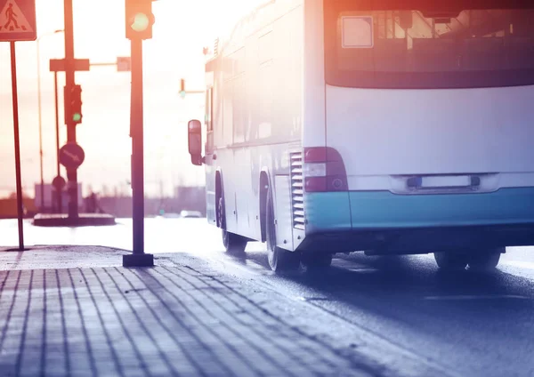 Ônibus se movendo na estrada na cidade no início da manhã — Fotografia de Stock