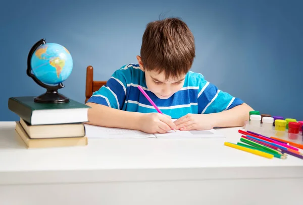Hét Éves Gyermek Otthon Írás Fiú Tanul Asztalnál Kék Háttér — Stock Fotó