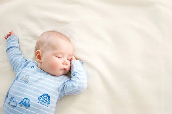 小男孩睡在柔软的白色毛毯上 — 图库照片