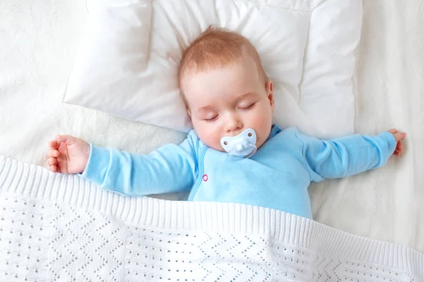 7个月大的婴儿睡在白色毯子和枕头上 昏昏欲睡的孩子在柔软的床上用品与奶嘴 — 图库照片