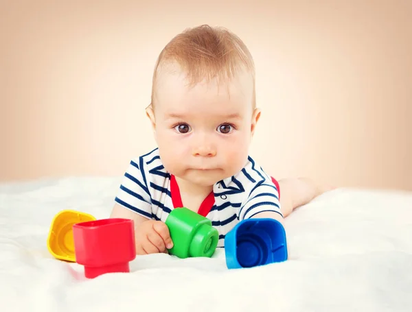 9个月大的婴儿躺在床上的白色毯子 可爱的男孩玩立方体 — 图库照片