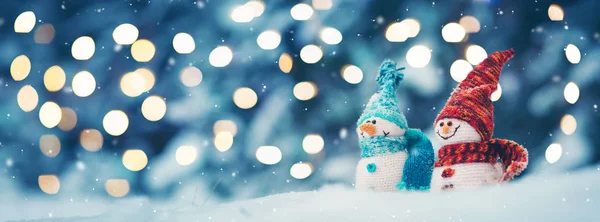 Trochę snowmans na miękkim śniegu na niebieskim tle — Zdjęcie stockowe