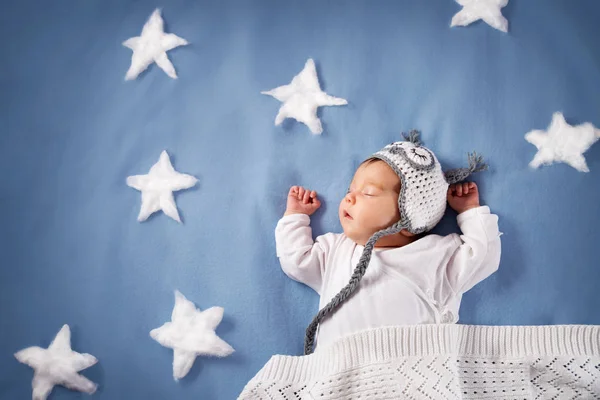 可爱的新生女婴躺在床上 2个月大的孩子在猫头鹰帽子睡觉在蓝色毯子与星 — 图库照片