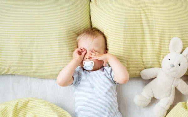 Bir Yaşında Bir Bebek Yeşil Bir Yatak Ile Yatakta Yatıyor — Stok fotoğraf