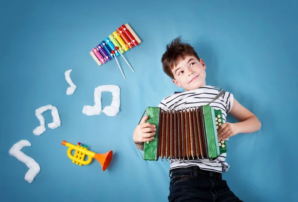 Glücklicher Siebenjähriger Junge Auf Blauem Deckenhintergrund Mit Ziehharmonika Und Musiknoten — Stockfoto