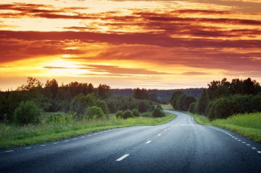 asphalt road view in countryside at beautiful sunset clipart
