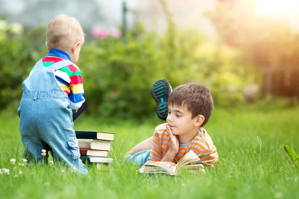 Семь Лет Ребенок Читает Книгу Лежащую Траве — стоковое фото
