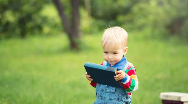 Bir Yaşında Bebek Bahçede Çimlerin Üzerine Oturan Bir Kitap Okuma — Stok fotoğraf