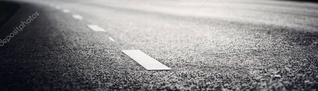 Black asphalt road and white dividing lines