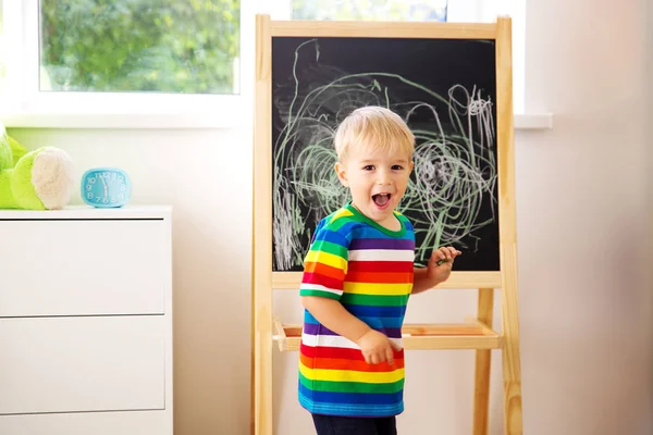黒板に子供の絵を描く 黒板のある部屋に立つ少年 — ストック写真