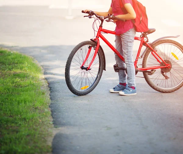 Dziecko z plecakiem, jazda na rowerze w parku, w pobliżu szkoły — Zdjęcie stockowe