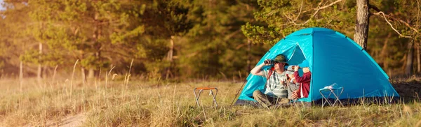 Família descansando com tenda na natureza ao pôr do sol — Fotografia de Stock