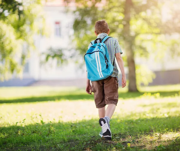 Ragazzo con lo zaino davanti a un edificio scolastico — Foto Stock