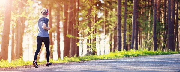 Giovane donna che corre nel parco — Foto Stock