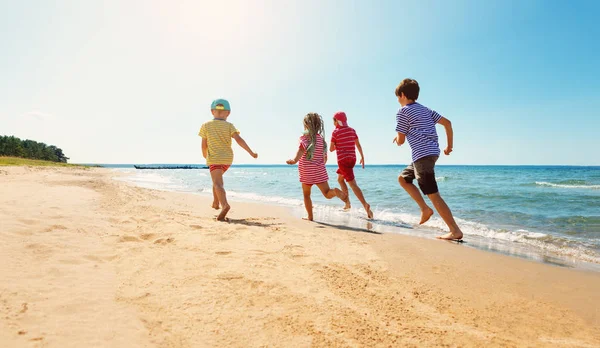 Niños felices de vacaciones en la playa corriendo en el agua — Foto de Stock