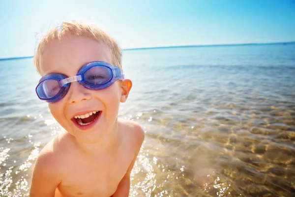 Fyra år gammal pojke som leker på stranden med simglasögon — Stockfoto