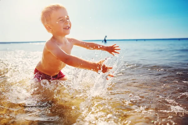 Trzyletni chłopiec bawiący się na plaży pierścieniem pływackim — Zdjęcie stockowe