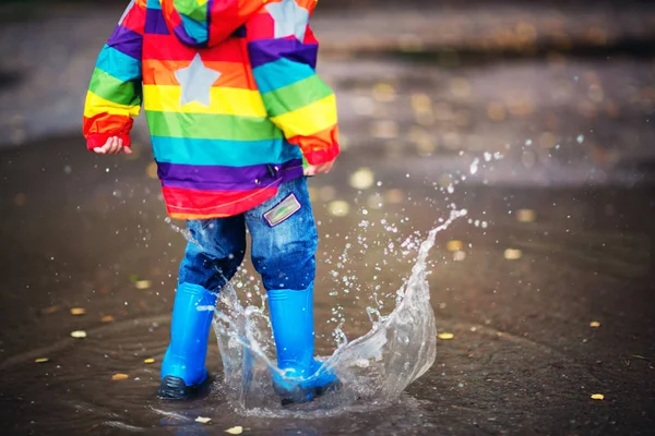 Dziecko spacerujące w walijkach w kałuży podczas deszczowej pogody — Zdjęcie stockowe