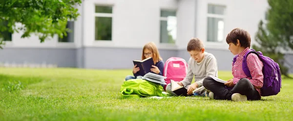 Barn med ryggsäckar står i parken nära skolan — Stockfoto