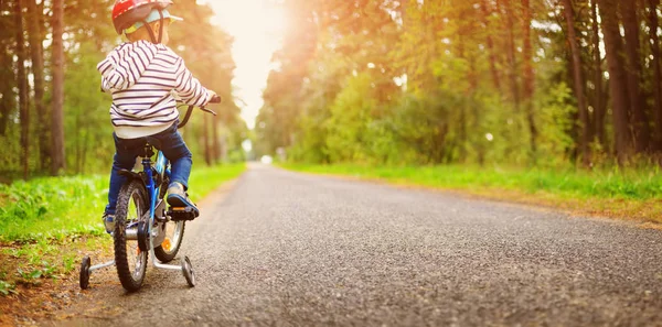 Ein Kind auf einem Fahrrad mit Helm — Stockfoto