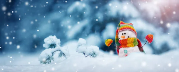 Pequeño muñeco de nieve sobre nieve suave sobre fondo azul — Foto de Stock