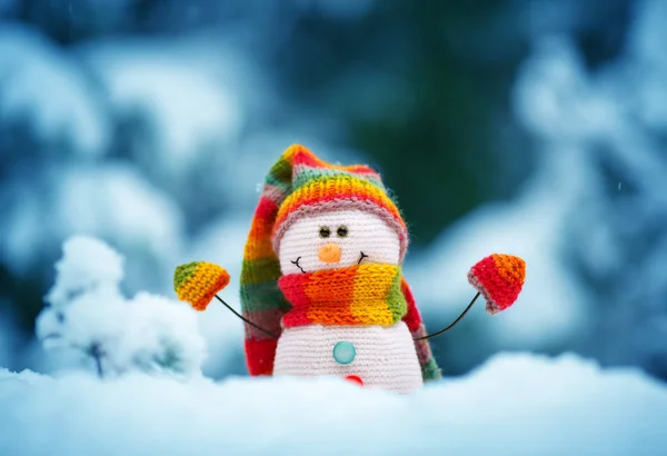 Pequeño muñeco de nieve sobre nieve suave sobre fondo azul — Foto de Stock