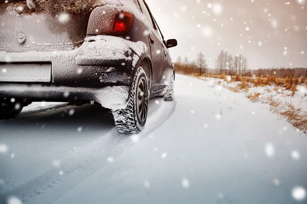 Pneus de carro na estrada de inverno coberto com neve — Fotografia de Stock