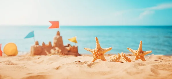 Песчаный замок на пляже в море летом — стоковое фото