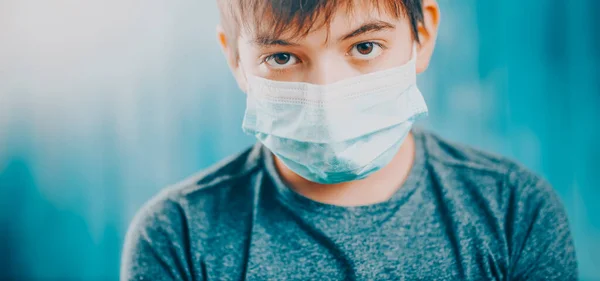 Garçon en masque médical de protection du visage à l'intérieur sur fond bleu — Photo