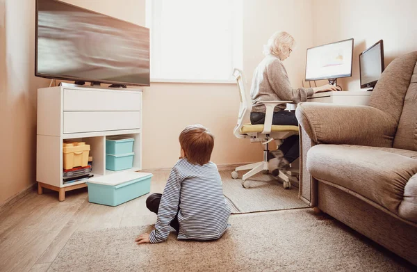 Femme travaillant à la maison avec un petit enfant. — Photo