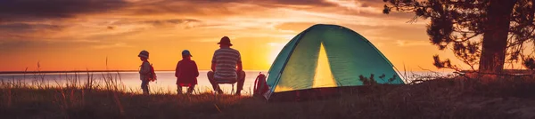 Rodzinny odpoczynek z namiotem w naturze o zachodzie słońca — Zdjęcie stockowe
