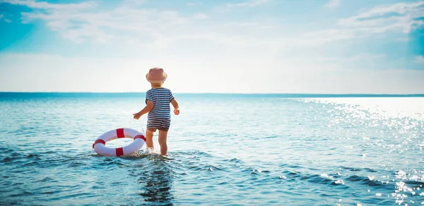 Mały chłopiec bawiący się na plaży w kapeluszu — Zdjęcie stockowe