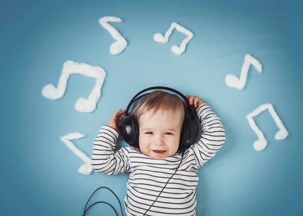 Mały chłopiec na tle niebieski koc ze słuchawkami — Zdjęcie stockowe