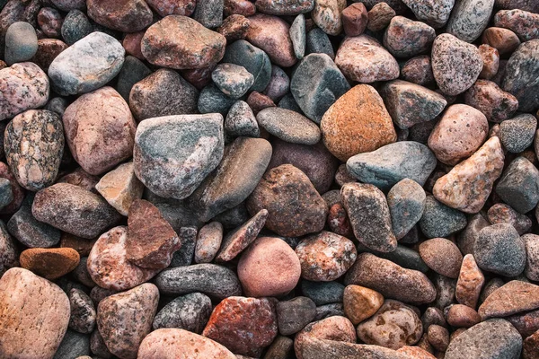 Struktur med flerfärgade stenar på stenig strand — Stockfoto