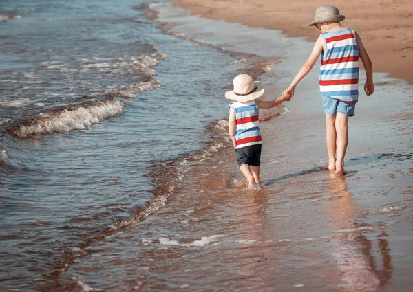 Dos hermanos caminan por la playa — Foto de Stock