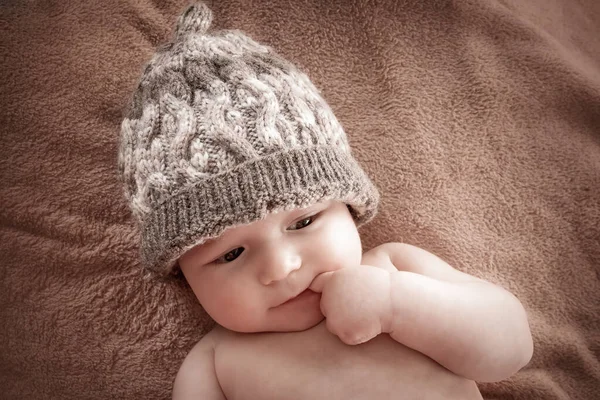 Baby i hatt på brun päls bakgrund — Stockfoto