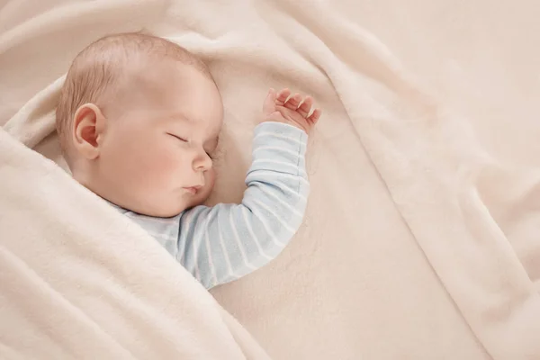 Bebé durmiendo cubierto con manta blanca suave — Foto de Stock