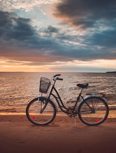 Eenzame fiets bij zonsondergang aan zee — Stockfoto