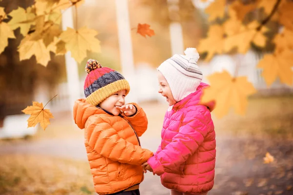Děti házejí listí v krásném podzimním dni — Stock fotografie