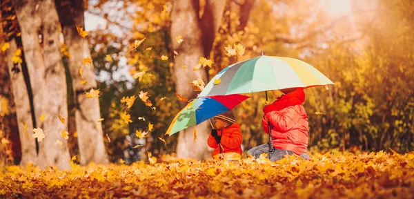 Barn med paraplyer i vackra höstdagar — Stockfoto