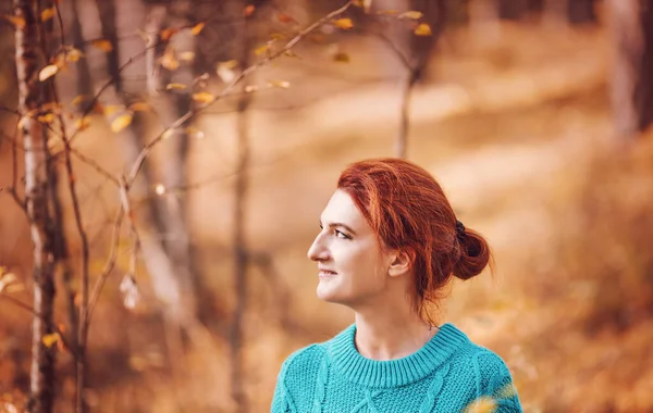 Красивая женщина с рыжими волосами в осеннем лесу. — стоковое фото