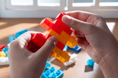 Çocuk oyuncak tuğlalarla ya da yapı taşlarıyla oynuyor. Hayal gücü ve çocukluk gelişimi kavramına odaklı yaratıcı süreç. 