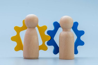 İki tahta insan figürü ve ahşap teçhizat. Takım çalışması, işbirliği, işbirliği, ortaklık, liderlik ve birlikte çalışma kavramı.