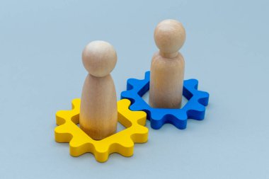 İki tahta insan figürü ve ahşap teçhizat. Takım çalışması, işbirliği, işbirliği, ortaklık, liderlik ve birlikte çalışma kavramı.